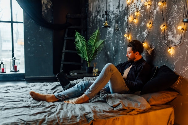 handsome-man-morning-time-lying-bed-with-laptop-looking-screen